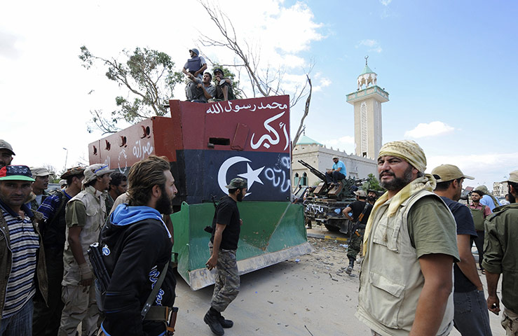 Sirte falls: NTC fighters gather around a makeshift armoured vehicle