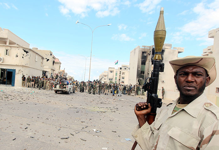 Sirte falls: An NTC fighter holds a rocket propelled grenade during a battle 