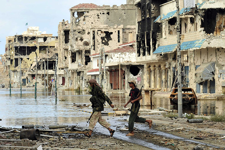 Sirte falls: Anti-Gaddafi fighters walk in an area where clashes took place 