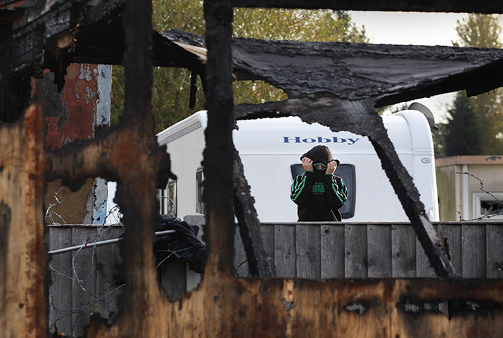 Dale Farm evictions: A traveller looks through the remains of a burnt building