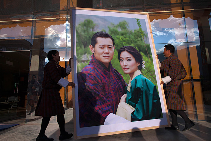 From the agencies: Workers carry a portrait of the King and future Queen of Bhutan 
