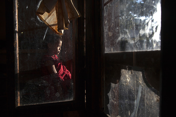 From the agencies: A novice monk looks out a window of the Dechen Phodrang monastery 