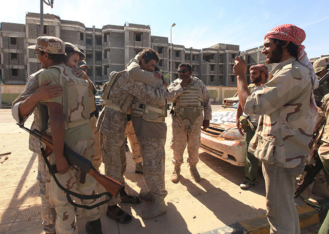 Sirte falls: Anti-Gaddafi fighters hug as they celebrate the fall of Sirte 