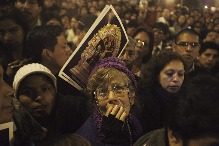 24 hours in pictures: Believer cries while watching religious procession, Peru