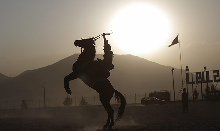 24 hours in pictures: An Afghan man rides a horse in a public par