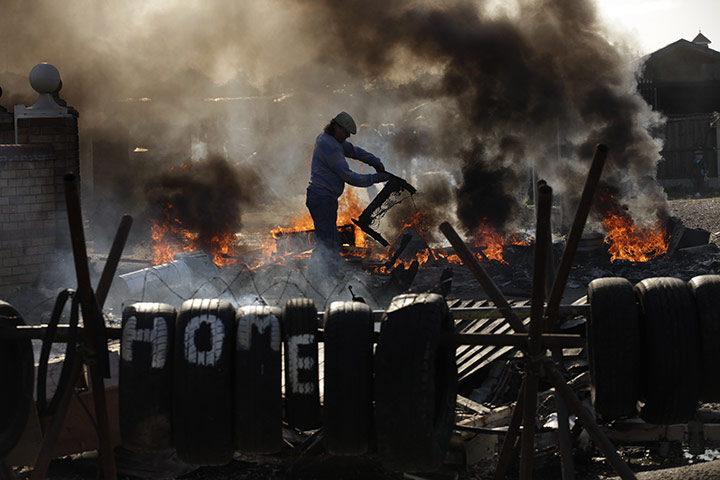 24 hours in pictures: A resident at a burning barricade at the Dale Farm travelers site