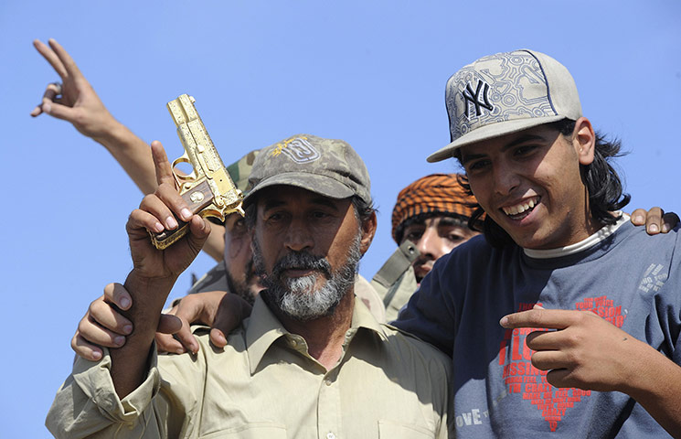 Sirte celebrations: NTC fighters hold what they claim to be the  gun of the ousted leader