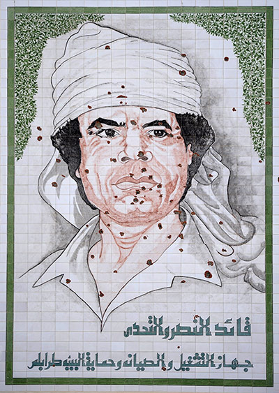 Cult of Gaddafi: A bullet-riddled mural depicting Gaddafi