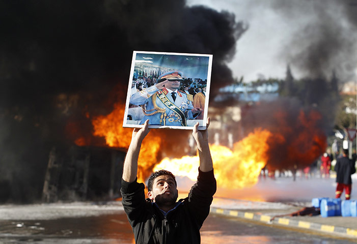 Cult of Gaddafi: Man holds up a poster of Libya's leader Muammar Gaddafi in Tripoli