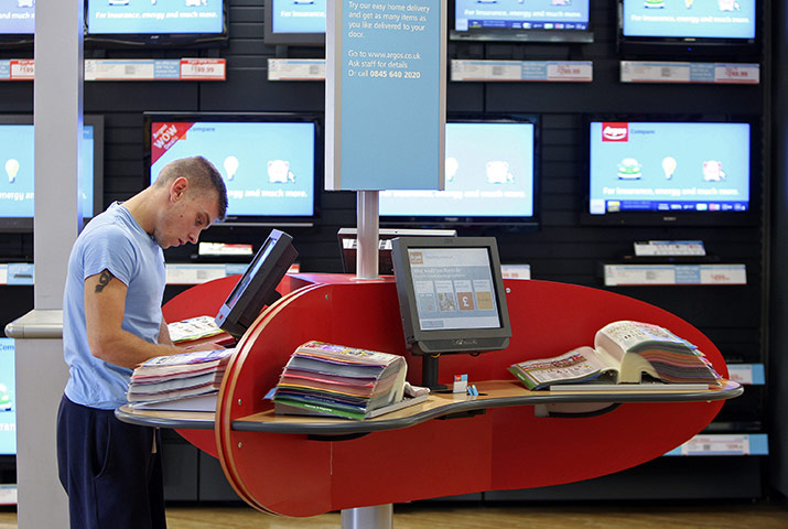 Week in Business: A customer browses a catalogue at an Argos store, in Enfield