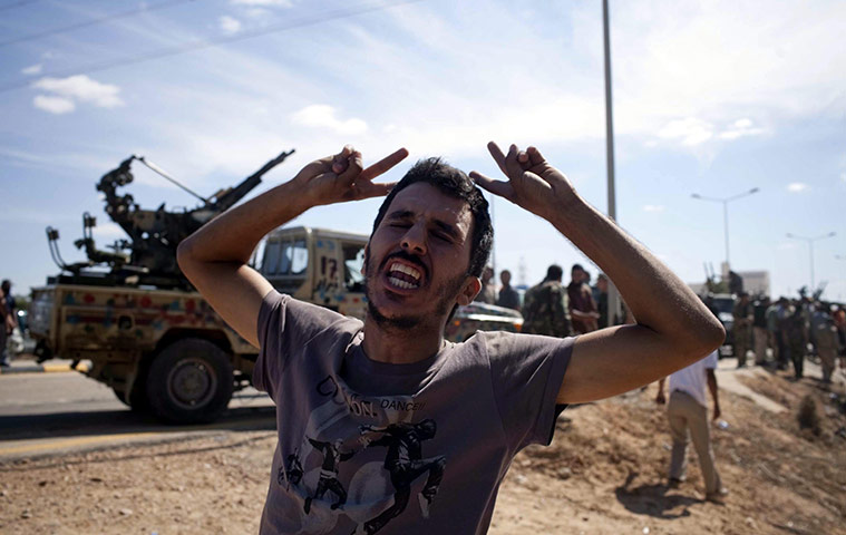 Libya celebrates: A Libyan rebel fighters reacts in Sirte