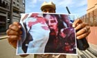 A NTC fighter holds a picture of the fallen leader Muammar Gaddafi, Libya