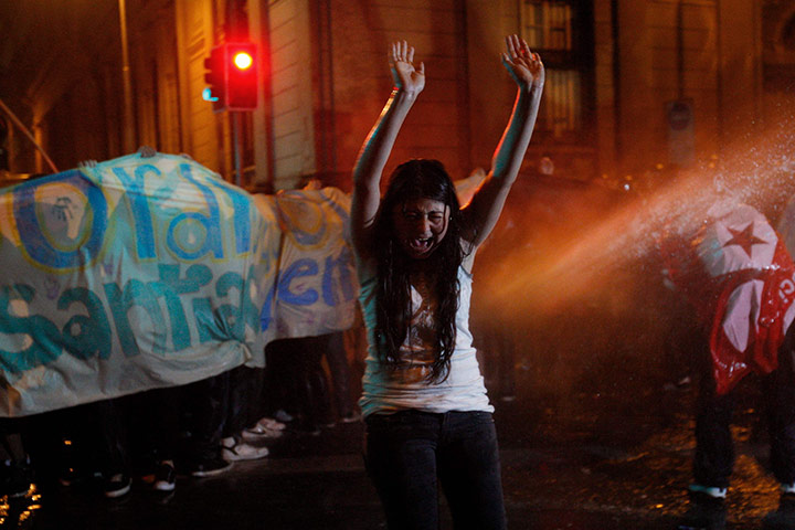 24 hours in pictures: Santiago, Chile: Demonstrators are hit by a jet of water