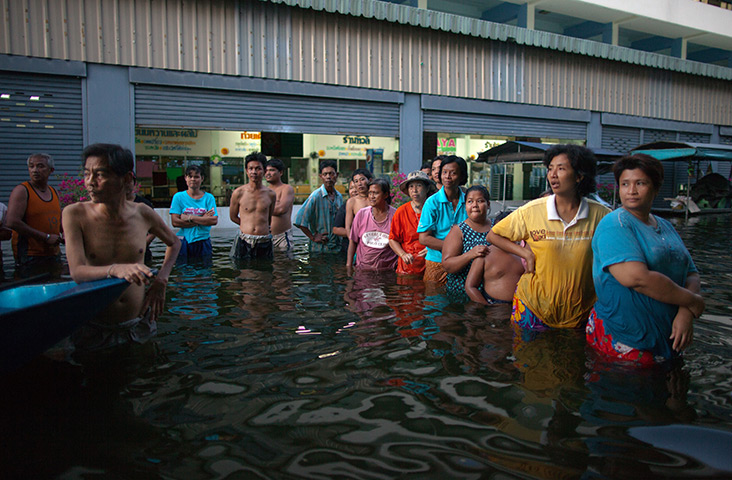 24 hours in pictures: Thai residents wait in line for food handouts at a evacuation centre