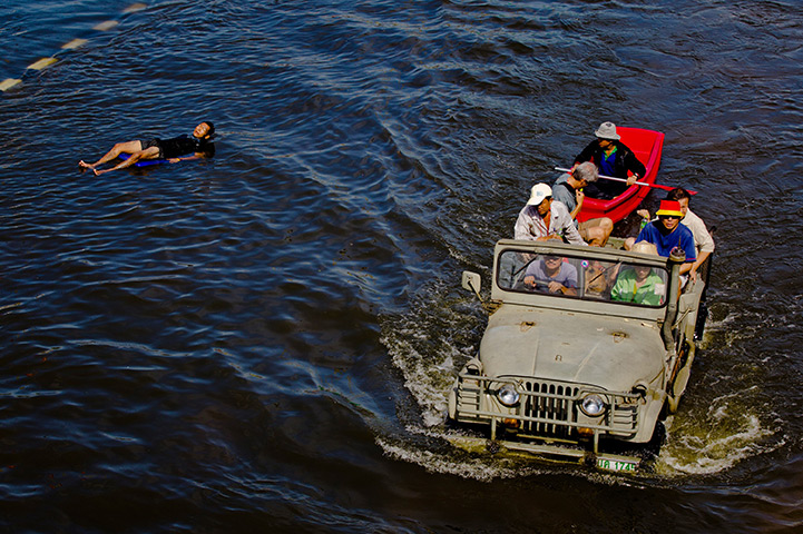 24 hours in pictures: Thai residents drive through flooded streets as a man floats downstream