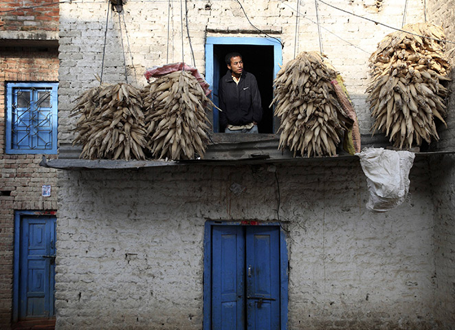 24 hours in pictures: A man looks out from a window of his hilltop home in Nepal