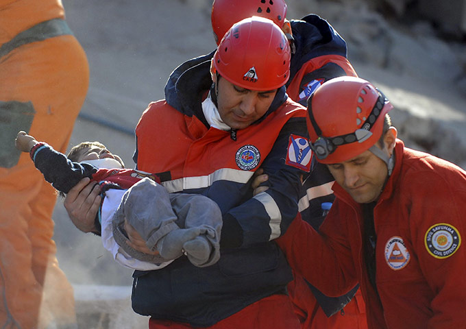 earthquake in turkey: A rescue worker carries a boy to an ambulance
