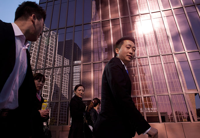 24 hours in pictures: Workers walk past an office building in Beijing, China