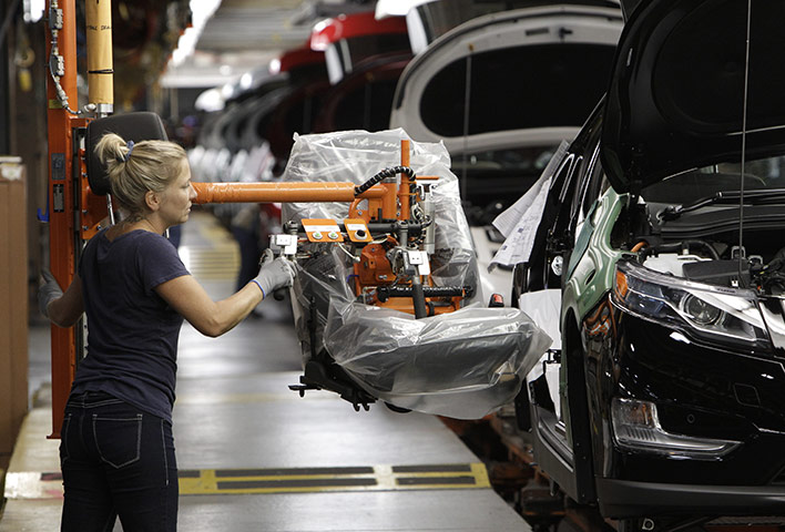 Chevrolet: An assembly line worker moves a seat into position for a Chevrolet Volt