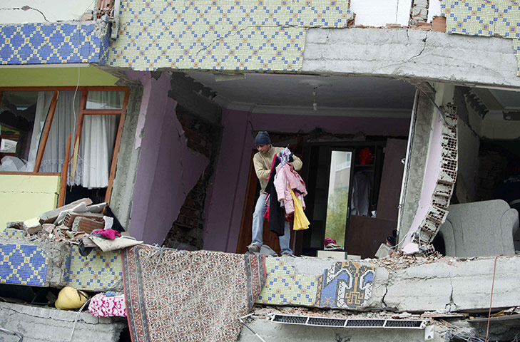 Turkey earthquake: An earthquake survivor collects belongings from a collapsed building, Ercis