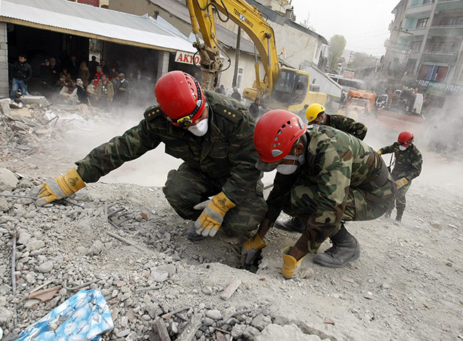 Turkey earthquake: An Azeri rescuer inspects a hole in the debris in Ercis