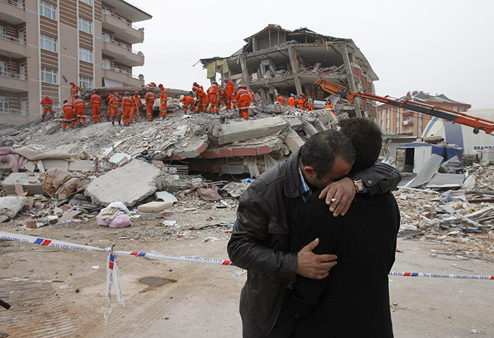 Turkey earthquake: Two men comfort each other near a collapsed building in Ercis