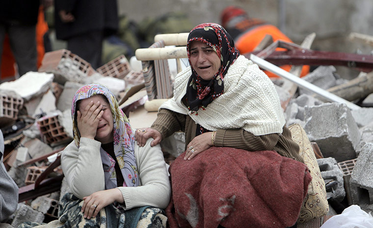 Turkey earthquake: Relatives of victims mourn in front of a collapsed building in Ercis