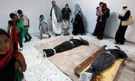 Libyans file past the bodies of Gaddafi and his son prior to their burial