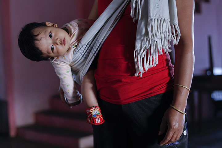 FTA: Adnan Abidi: A daughter-in-law of Ziona holds her grandson at their residence 