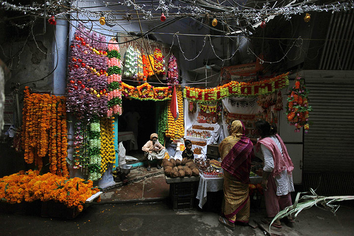Diwali festival of lights: Indian women buy floral decorations and prayer material
