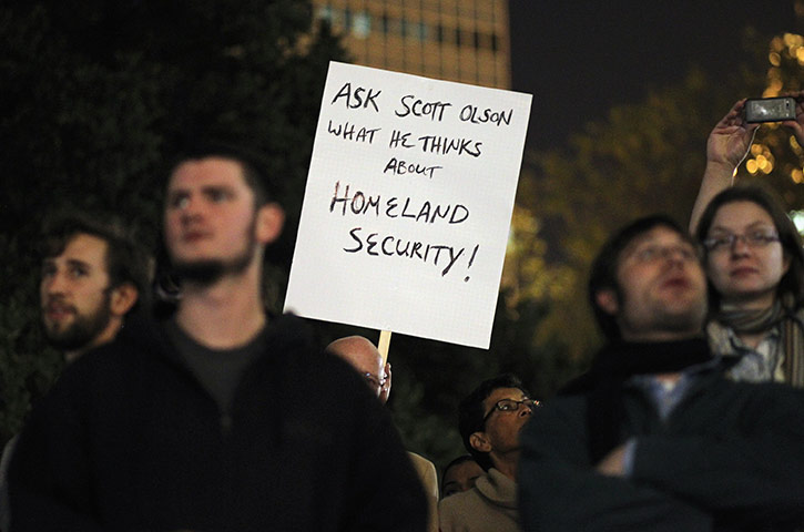 A protester holds up a sign referencing Scott Olsen via guardian.co.uk