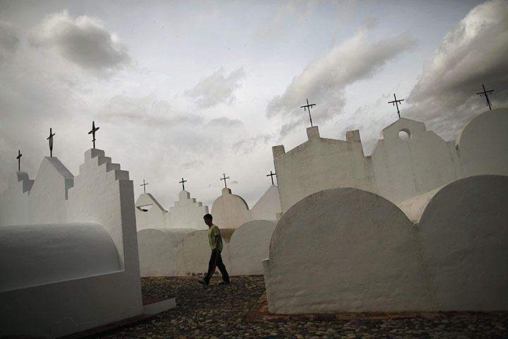 24 hours in pictures: Malaga, Spain: A man walks past tombstones at the cemetery of Casabermeja