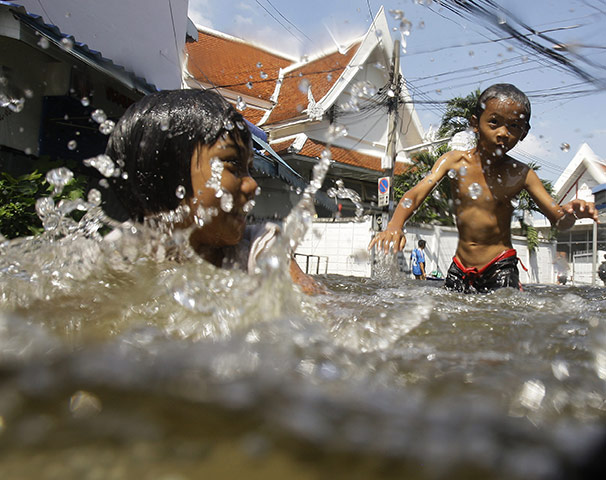 thailand flooding: Children play along a flooded area of Bangkok