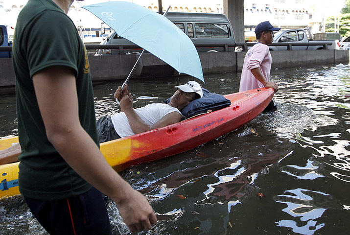 thailand flooding: A sick resident is evacuated by boat in Bangkok 