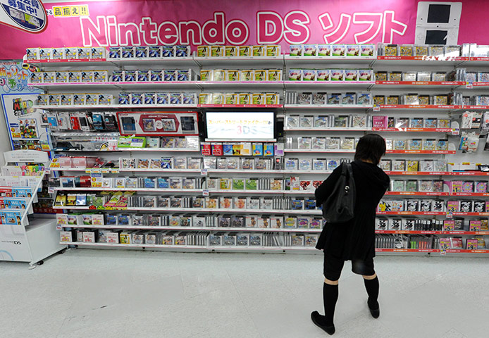 Week in Business: A Japanese consumer shops for Nintendo software at a store in Tokyo