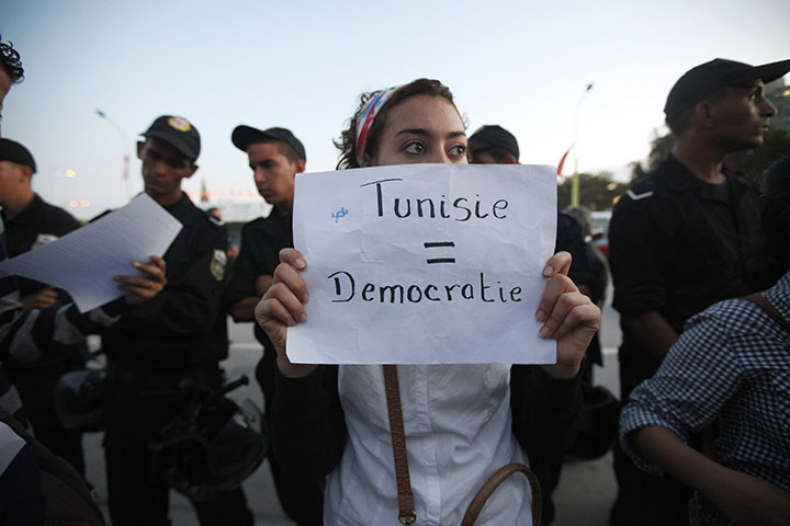 Tunisia elections: 26 October: A demonstrator holds a sign during a protest