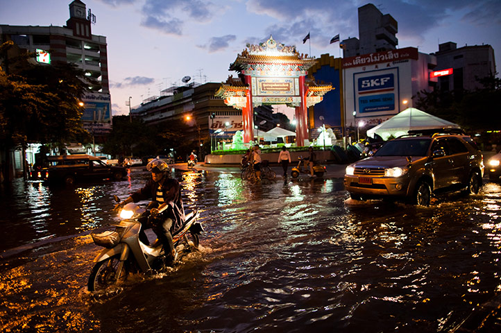 24 Hours: Bangkok, Thailand: Residents drive through a flooded street