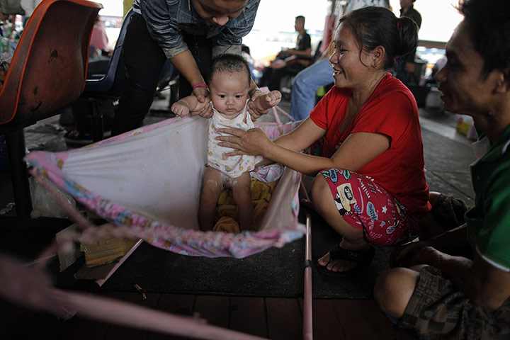 bangkok flooding: A baby is taken care of at a bus station