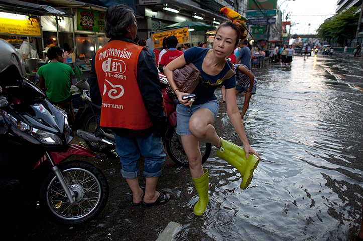 bangkok flooding: A woman fixes her wellington boots