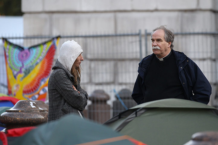St Paul's reopens: A campaigner speaks to a cleric outside St Paul's Cathedral