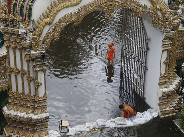 Bangkok: Thai Buddhist monks wade through floodwaters at Amarakire temple