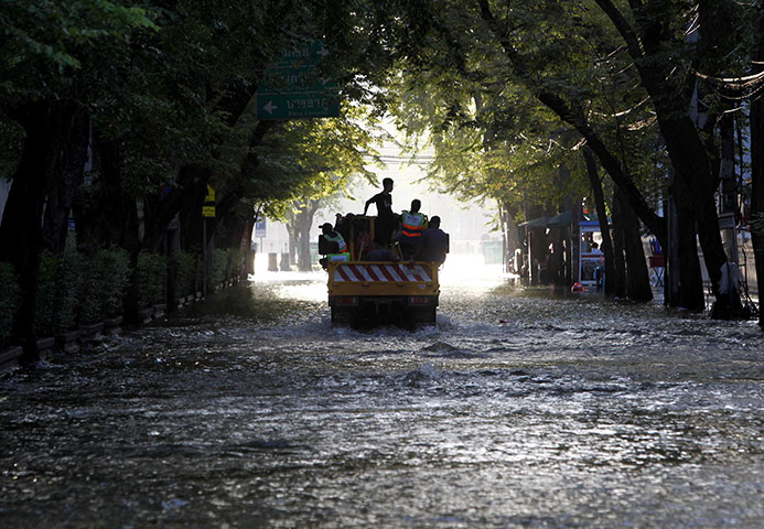 Bangkok: A motorist drives through a flooded street in Bangkok
