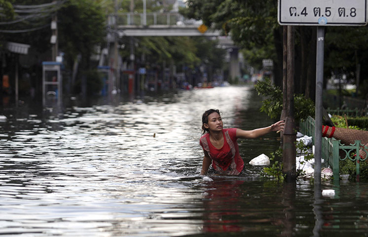 Bangkok: A Thai woman struggles to wade through a flooded street 