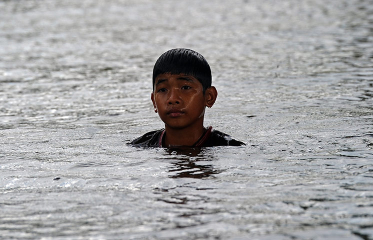 Bangkok: A Thai child swims in floodwaters