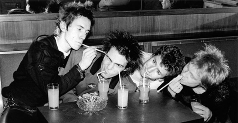 Rock Seen by Bob Gruen: The Sex Pistols playing with straws at a cafe in Luxembourg