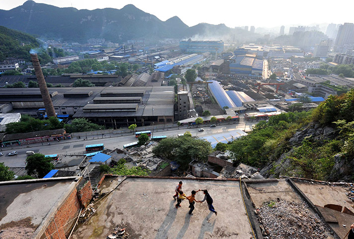 Guiyang urbanisation: Chinese children play on the roof of a house at a slum area