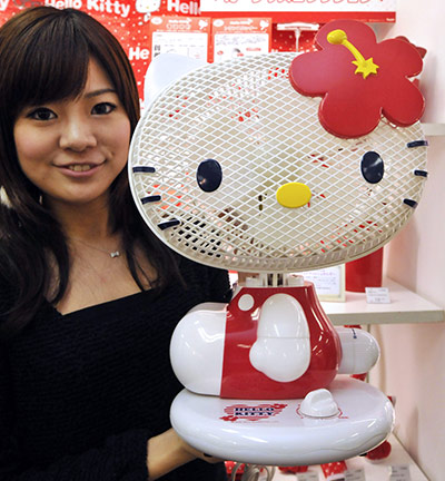 Hello Kitty: A Sanrio employee displays a fan shaped as character 'Hello Kitty'