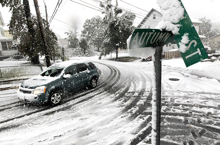 Snow in US: A vehicle makes its way at the snow-covered intersection