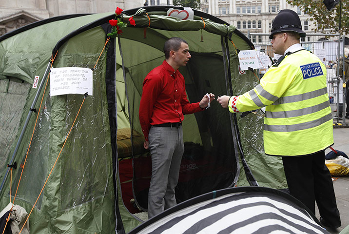 Occupy London protests: A police officer speaks with a demonstrator camped outside St Paul's 
