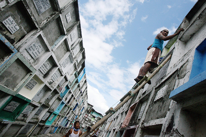 24 hours: Navotas, Philippines: A Filipino man prepares the grave of his relative